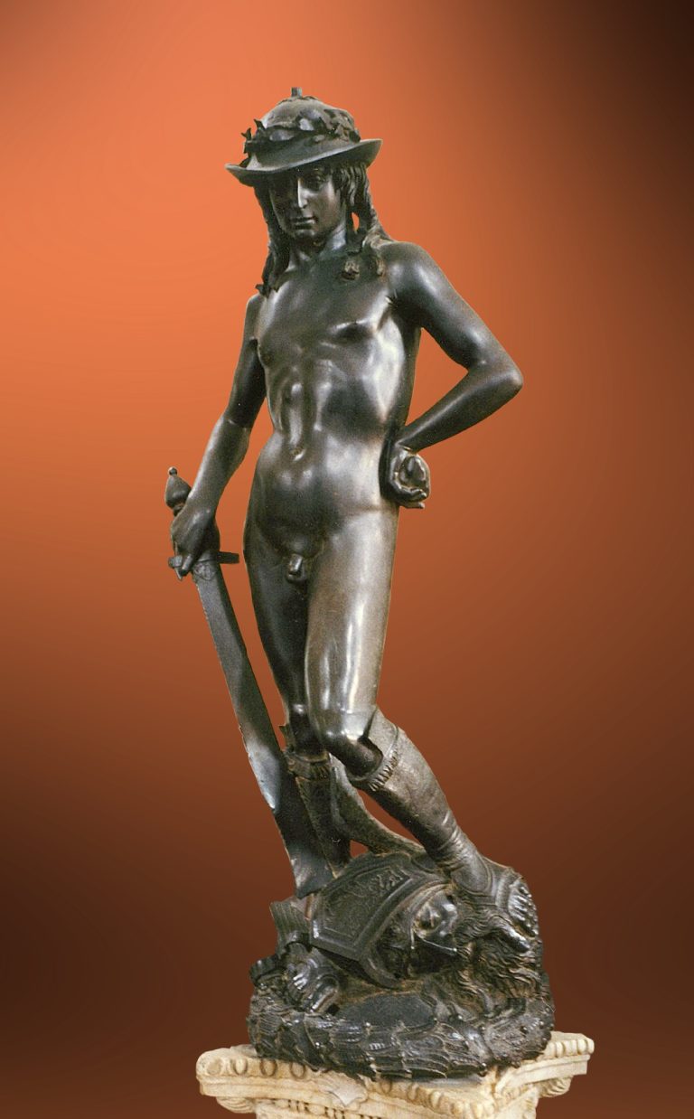 Biblical shepherd boy David with a triumphant, enigmatic smile, posing naked except for boots and a laurel-topped hat, with his foot on Goliath's severed head