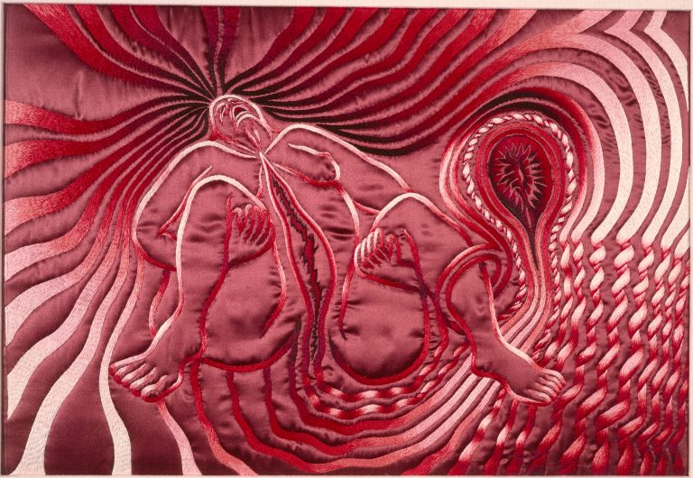 Textile work depicting a stylized female nude with exposed vulva, rendered in embroidered, symbolic, anatomical imagery emphasizing the physicality of childbirth